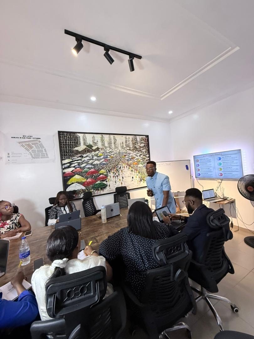 Tion Joseph training a marketing team on paid ads inside a modern office boardroom
